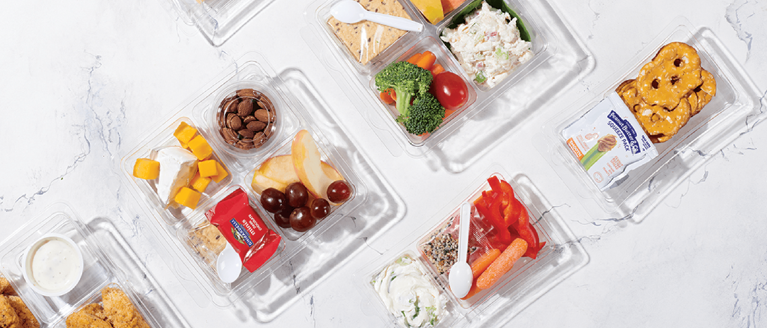 A snack box containing fruits, cheese and nuts